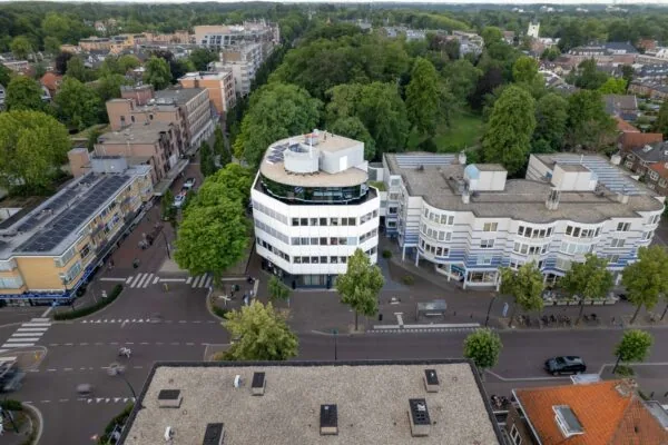 Luchtfoto van de 1e Hogeweg in Zeist met kenmerkende witte kantoorgebouwen en omliggend groen.